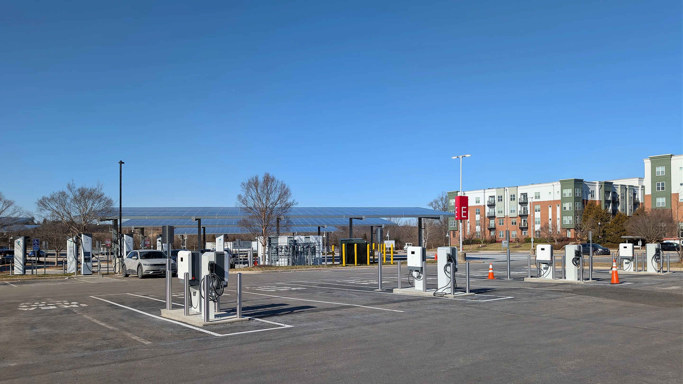 A large open charging forecourt with rows of charging bays